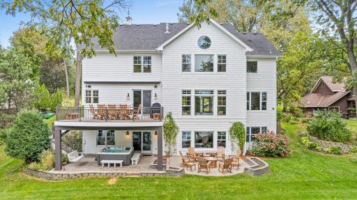 The rear view showcases the multitude of windows that overlook the beautiful property. The center window in the upper level is the primary bedroom. The lake views are spectacular from every level of the home.