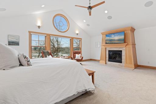 Alternate view of the primary bedroom showcases the soaring vault and gorgeous fireplace.