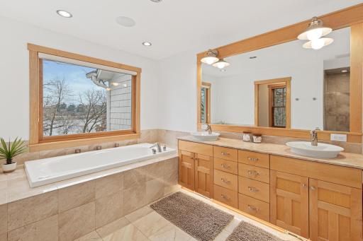 The fabulous views continue into the spa-like primary bathroom. The bathroom features a large double vanity with ample storage, a deep and jetted soaking tub, a walk-in shower, separate water closet, and in-floor heat!