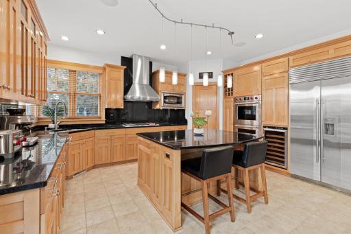 The kitchen features high end stainless steel luxury brand appliances including: Wolf cooktop & hood, Wolf double ovens, an oversized Sub-Zero fridge/freezer, Avanti wine cooler and Thermador dishwasher.