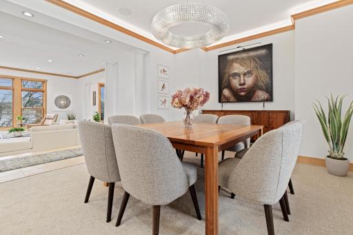 The formal dining room is situated at the front of the house and is open to the living room. This rooms has a fabulous chandelier, uplighting above the crown molding, 2 large windows for great light, plus views to the lake.