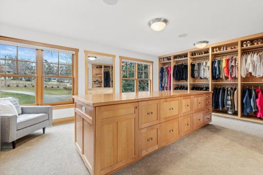 This walk-in closet is the epitome of luxury. It is outfitted with a combined 28 feet of floor to ceiling hanging space and shelving, as well as the 3'6"x10'8" center dressing table with 24 drawers and 2 large cabinets.