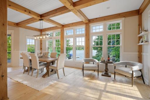 The adjoining informal dining room dazzles with a gridded accent ceiling of wooden beams and shiplap.