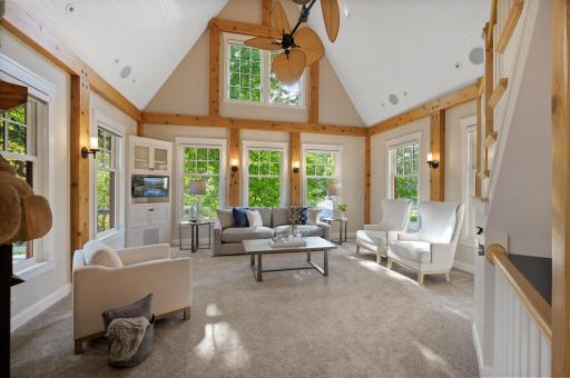 The spacious living room is a masterpiece with its towering 23-foot vaulted ceilings adorned in shiplap.