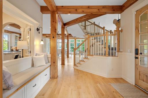 Gorgeous wood floors beneath soaring 10-foot ceilings, and a built-in bench with storage adds function to the foyerâs charm.