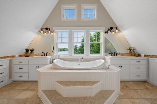 A peaceful retreat awaits with a spa-like primary bath featuring vaulted shiplap ceilings, separate dual sinks, a large soaking jetted tub, and a walk-in steam shower with built-in bench and tile surround.