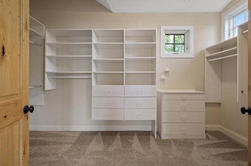 The spacious walk-in closet is fitted with custom wood built-ins.