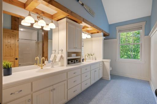 The enormous upper-level shared bathroom is adorned with stunning blue tile floors, and a large double vanity.
