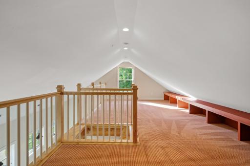 Perfect for a kids' play area or reading nook, the upper-level loft is bright and fun with its playful carpet and built-in shelving.
