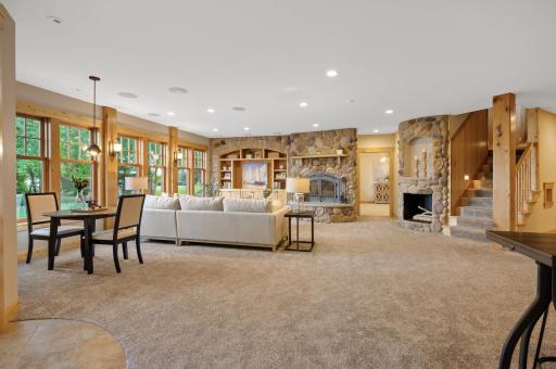 The walk-out lower level is designed for entertainment with 9-foot ceilings, a large family room featuring a cozy wood-burning fireplace with floor-to-ceiling stone surround.