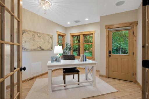 The adjacent den features French doors and wood floors, offering versatility and private access to the outdoors.