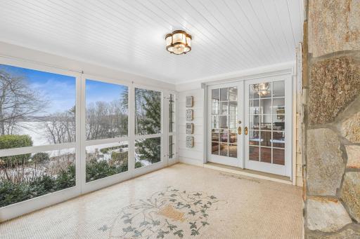 The screened in porch boasts a custom tiled mosaic floor and automatic blinds.