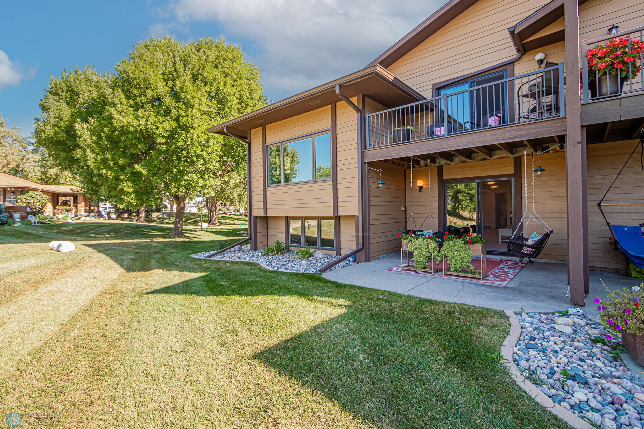 Lake side of home, primary suite deck and walk out level patio