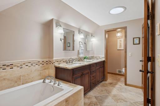 Luxury meets function in this updated bath with a soaking tub, separate walk-in shower, and double sinks.