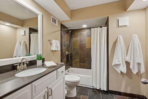 Updated lower-level bath with a tub and shower.