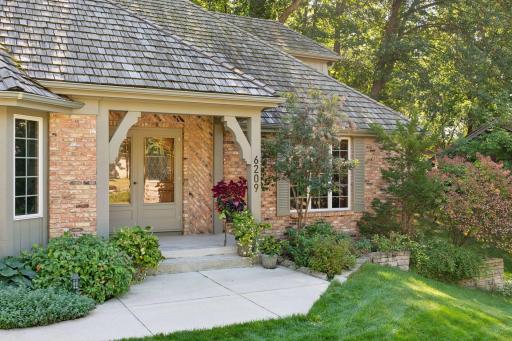 Charming curb appeal with lush landscaping and a welcoming front porch.