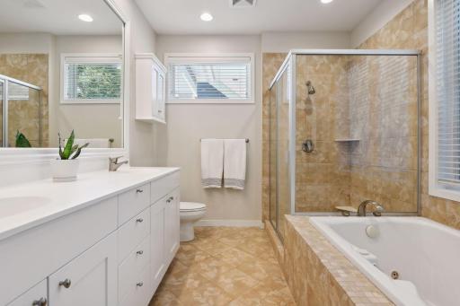 Primary bath offers dual sinks, separate whirlpool tub, and large walk-in shower