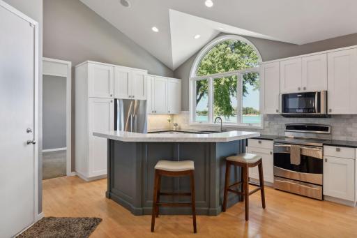 Crisp white cabinets, SS appliances, and soaring vaulted ceilings
