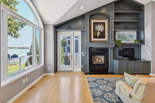 Gas fireplace, built-ins, and access to the upper porch are additional highlights of the living area