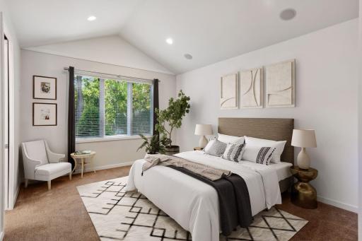 Main level primary suite with vaulted ceilings featuring built-in speakers