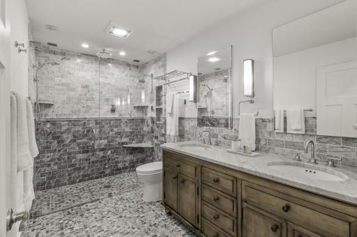 Luxurious Owner's Suite Bathroom includes In-Floor Heating, Walk-In Shower Stall, Powered Medicine Cabinets with Night Lights, and Dual Sinks