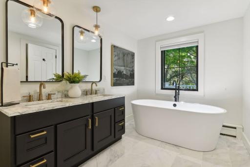 Indulge in relaxation with a sleek modern soaking tub in your primary suite, creating a tranquil retreat for unwinding after a long day.