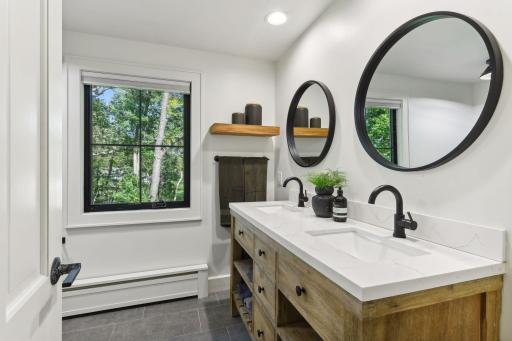 Another beautifully renovated luminous upper level bath complete with double sinks and floating shelves.