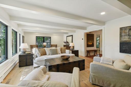 Charm and character abound in this main level family room, showcasing beautiful original wood beams.