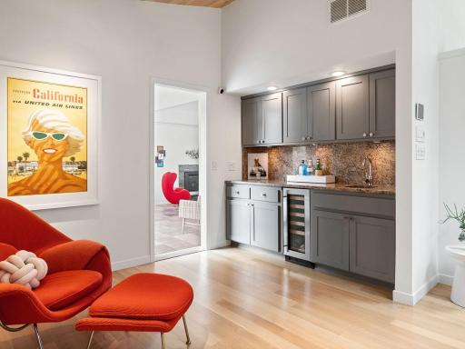 Wet bar with custom cabinetry and wine fridge.