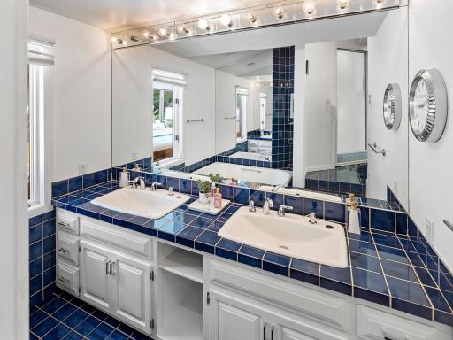 The original MCM primary bathroom is recessed and features a soaking tub and spacious walk-in shower.