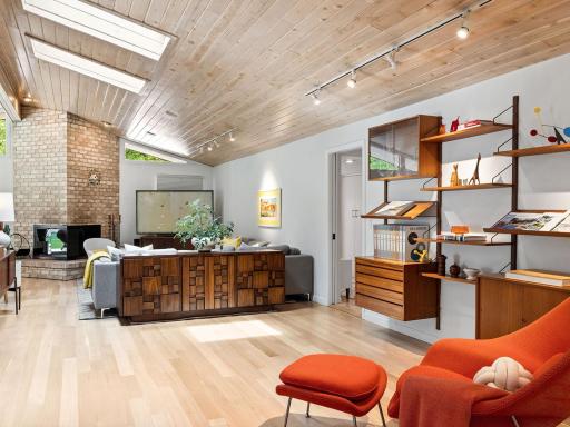 Vaulted ceilings, original fireplace and stunning white oak floors in the the main floor family room.