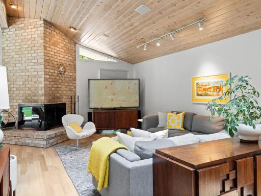 Original MCM double-sided wood-burning fireplace brings warmth to this space year round.