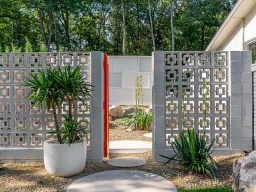 A custom breeze-block entrance leads to the backyard, paying homage to its Mid-Century Modern design!