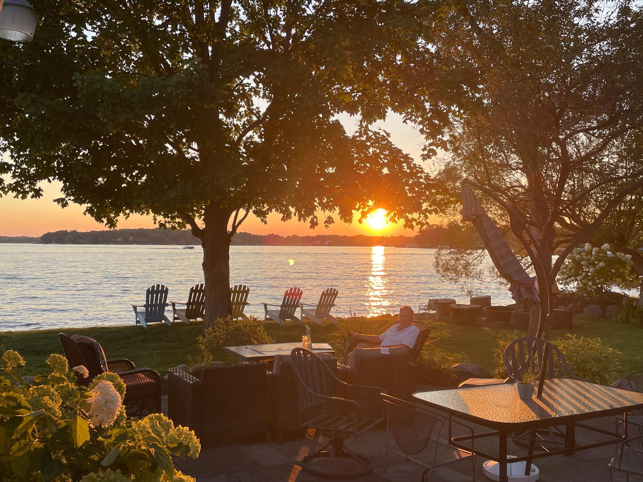 from patio door looking at sun setting includes chairs and mike in photo.jpg