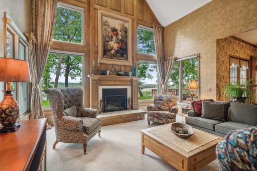 Great room with stunning river views and gas fireplace with beautiful millwork and marble surround