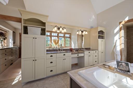 The expansive vanity provides plenty of room for personal items, while the custom cabinetry below offers abundant storage to keep everything organized and within easy reach.