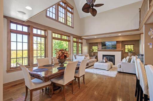 The living room features a cozy fireplace, large windows that flood the space with natural light & vaulted ceilings.