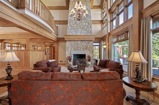 Expansive windows surround the room allowing abundant natural light to flooding the space. While the floor-to-ceiling limestone fireplace offers a cozy contrast.