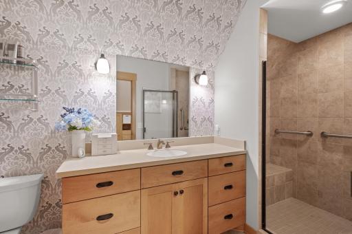 The suite also includes a 3/4 bathroom with a beautifully tiled shower, providing both comfort and style.