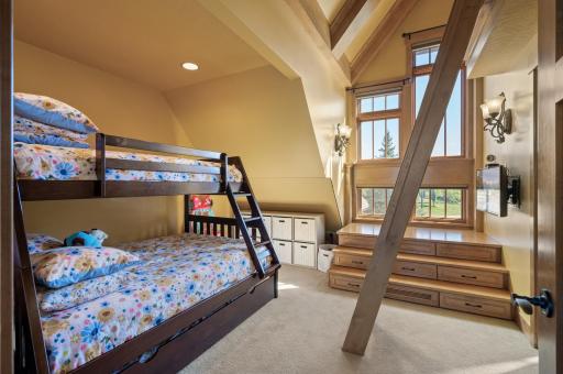 The upper level features two identical bedrooms, each offering a spacious layout and large windows that fill the rooms with natural light.