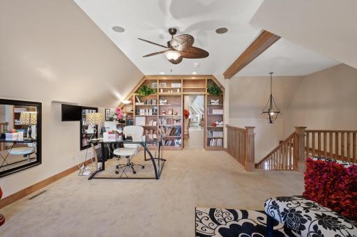 This peaceful loft space features custom-built bookshelves that leads seamlessly to the private guest or in-law suite, offering a quiet retreat with convenient access to its own separate living area.