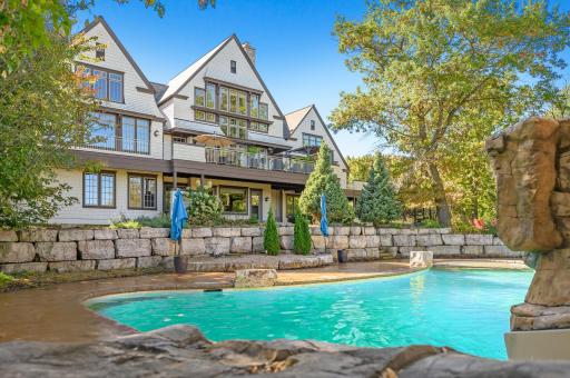 Layered boulder landscaping and mature trees complete this outdoor living space, creating a serene and natural backdrop.