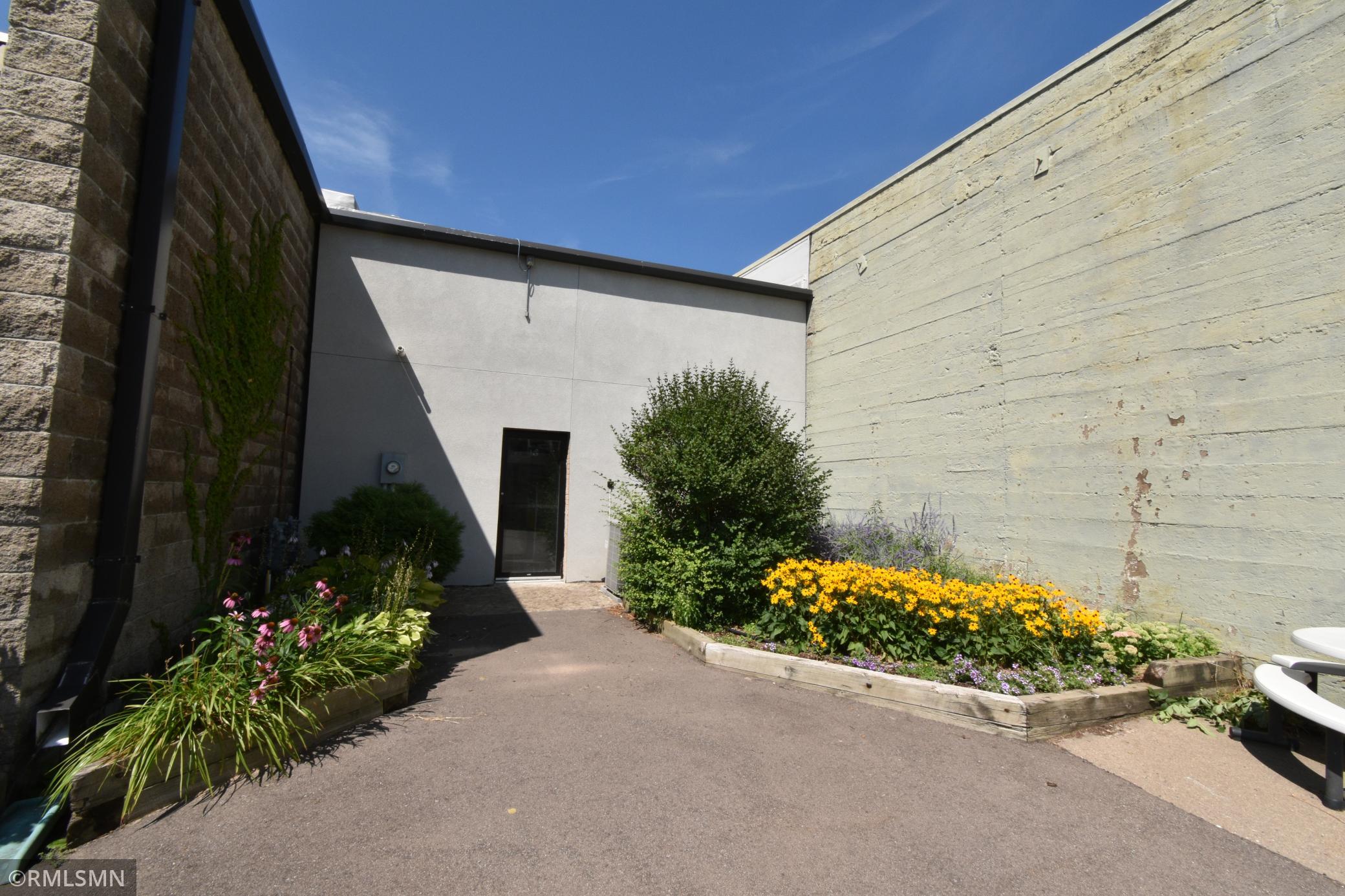 View of the patio in the back of the building adjacent to a parking lot.
