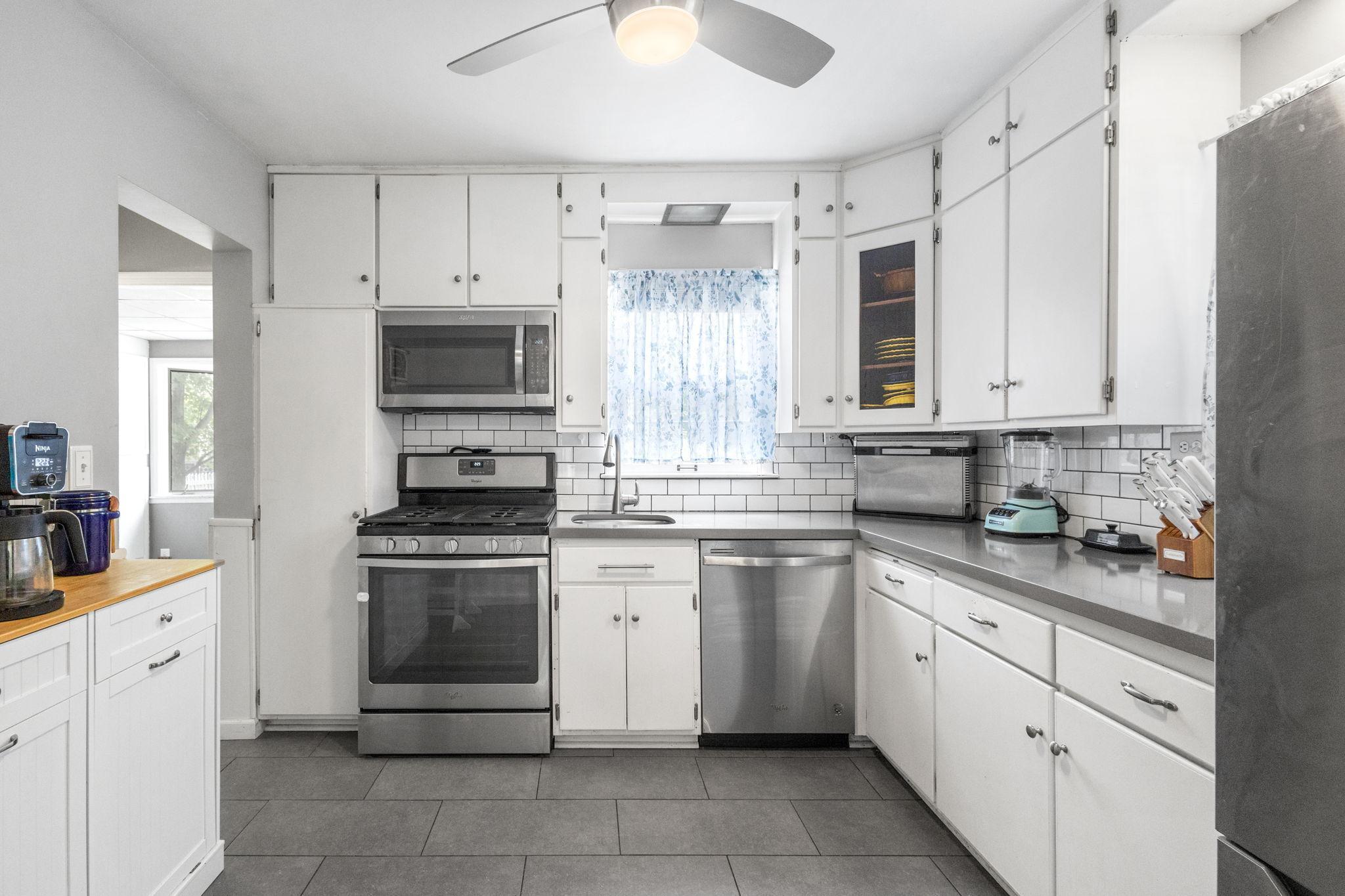 The updated kitchen boasts stainless steel appliances and a sleek stone countertop, seamlessly flowing into a separate dining area ideal for family gatherings.