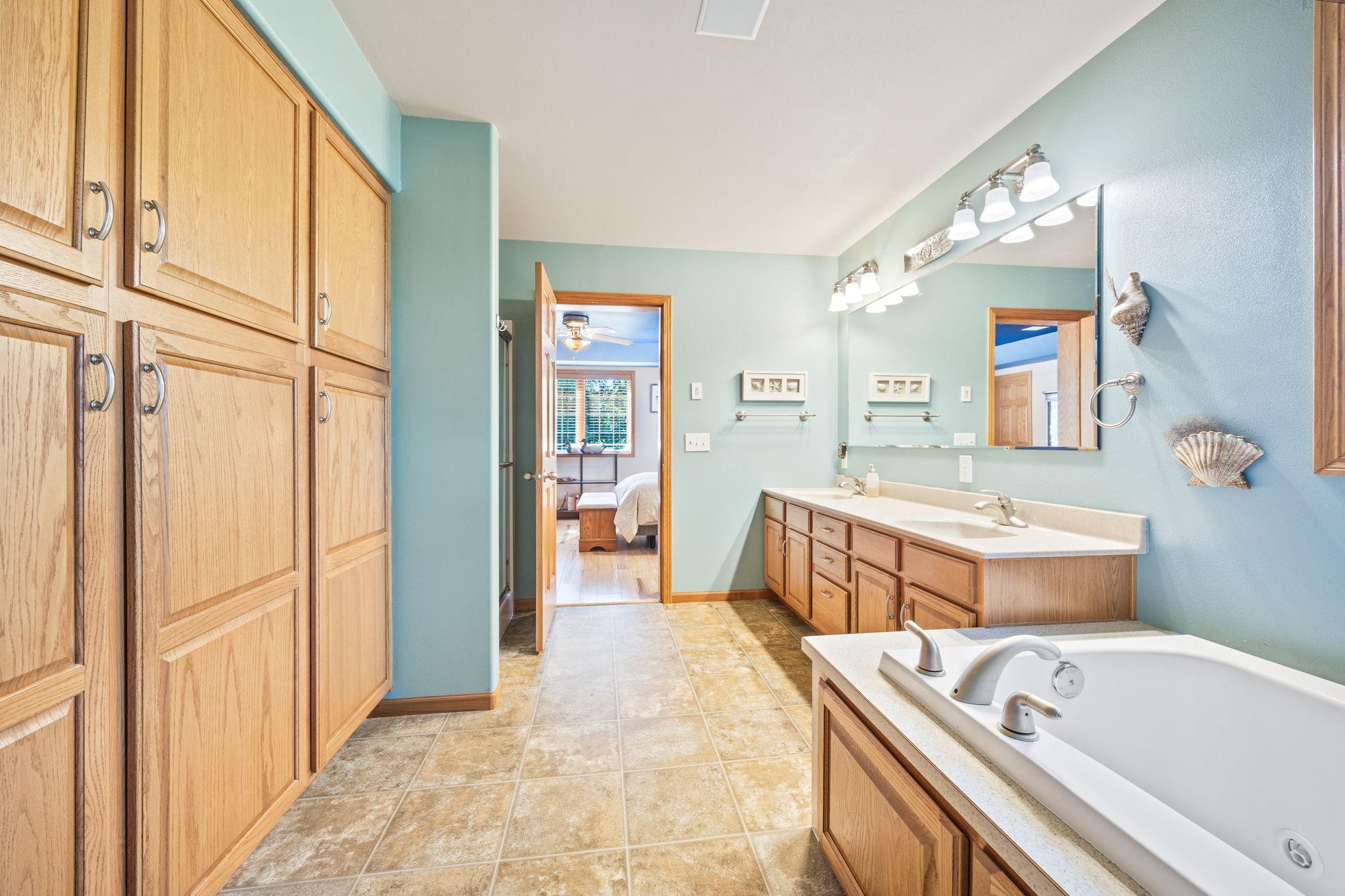 Primary bathroom with double vanity, jetted tub, and tons of storage.