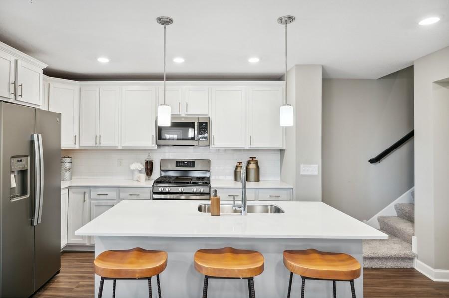 (Photo of decorated model, actual home's finishes vary) Welcome to your new home! This spacious kitchen features a large center island with quartz countertops, under mount sink, recessed lighting, LVP hardwood floors, stainless appliances and more!