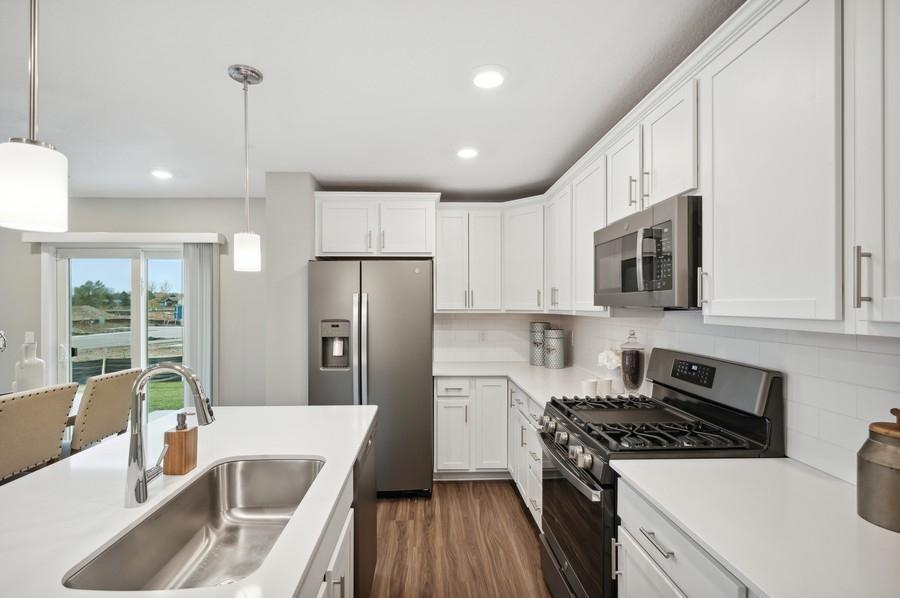 (Photo of decorated model, actual home's finishes vary) Enjoy plenty of seating at the kitchen island and dining area adjacent to the kitchen. Perfect for entertaining or having a family meal together.