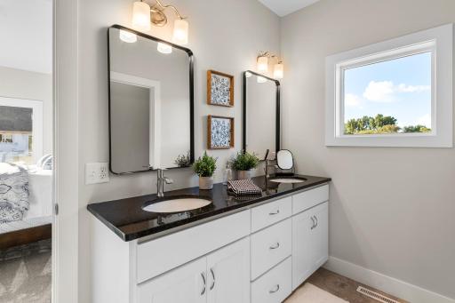 The primary ensuite features an oversized tiled walk-in shower, and a sprawling walk-in closet.