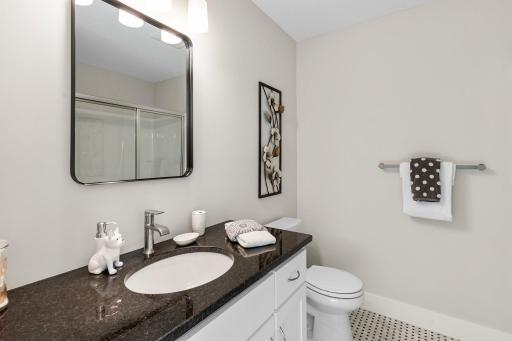 Conveniently placed between the two bedrooms is a modern 3/4 bathroom, complete with a sleek vanity, stylish fixtures, and a roomy shower. This bathroom provides convenience and comfort for lower-level living.