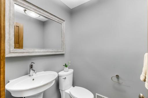 1/2 bathroom features classic pedestal sink and tile flooring